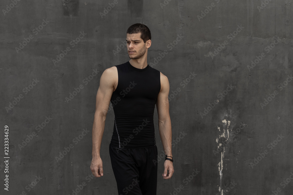 Sport model man posing gray wall background