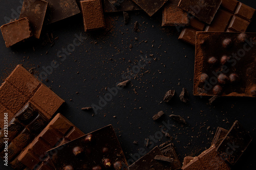 top view of various delicious chocolate pieces on black background