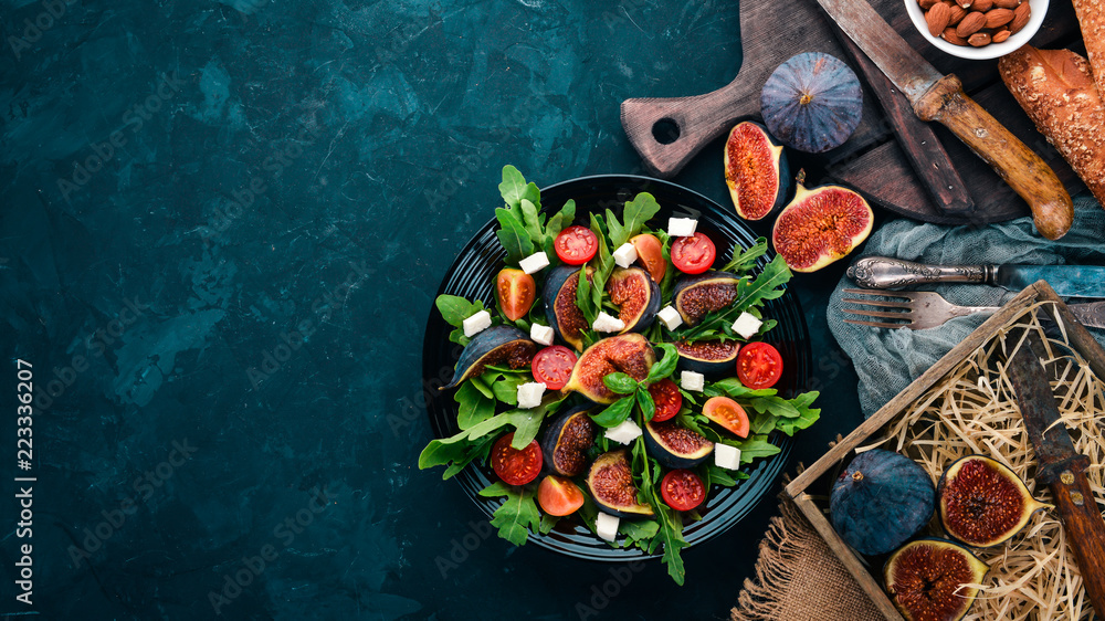 Fresh salad with figs, arugula leaves, cherry tomatoes and feta cheese. Free space for text. Top view. Fresh salad with figs, arugula leaves, cherry tomatoes and feta cheese. Free space for text. Top view.
