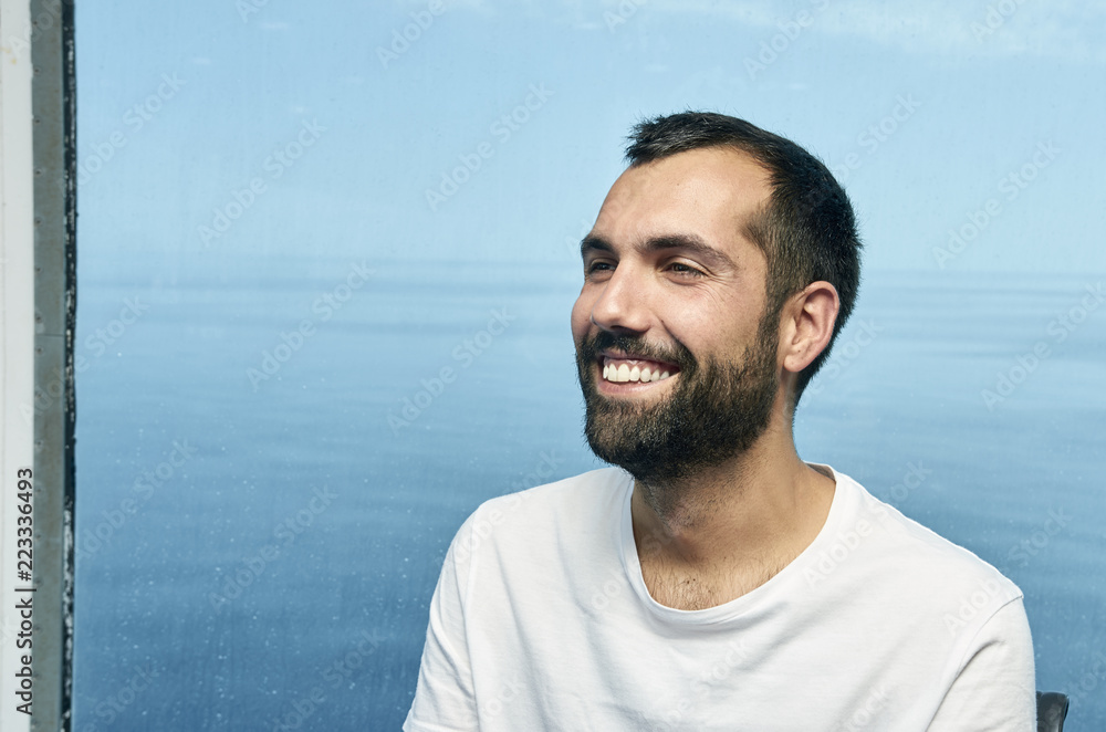 Handsome man smiling on the deck of a ship during holidays. Handsome man smiling on the deck of a ship during holidays.