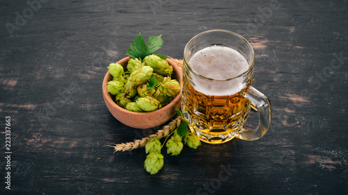 Beer in a glass mug. On a black wooden table. Free space for text. Top view.