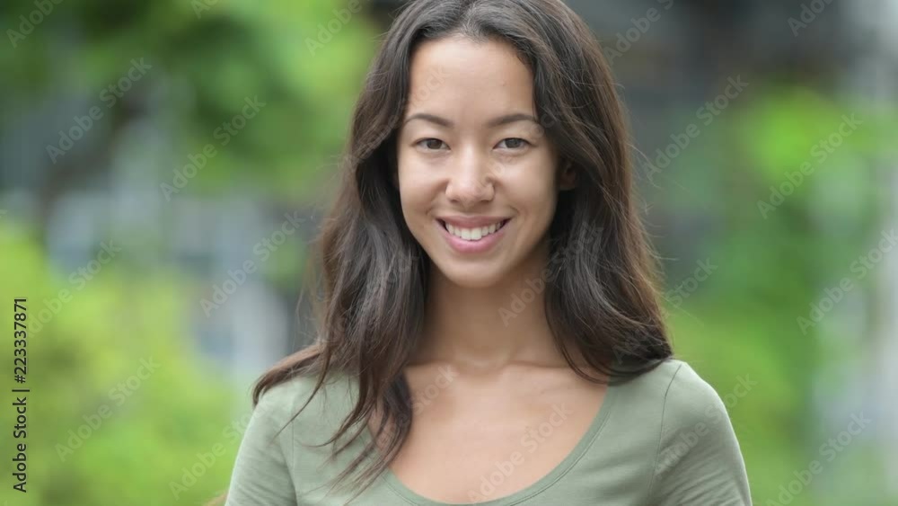 Young happy beautiful multi-ethnic woman smiling outdoors Young happy beautiful multi-ethnic woman smiling outdoors