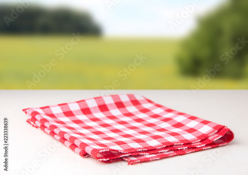 Red napkin in a cage lies on a table, behind a background