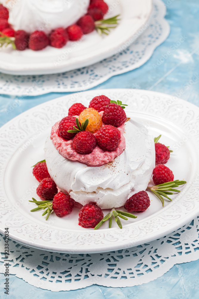 Meringue pavlova cake with whipped cream and fresh raspberries Meringue pavlova cake with whipped cream and fresh raspberries