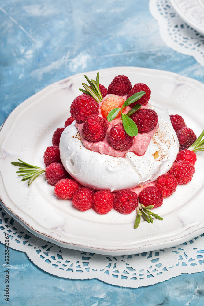 Meringue pavlova cake with whipped cream and fresh raspberries Meringue pavlova cake with whipped cream and fresh raspberries