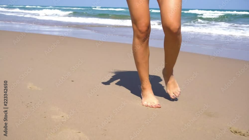 close up shots of a young woman walking along the beach in 4K