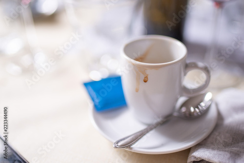 Tracce di caffè rimaste sulla tazzina dopo la consumazione al tavolo photo