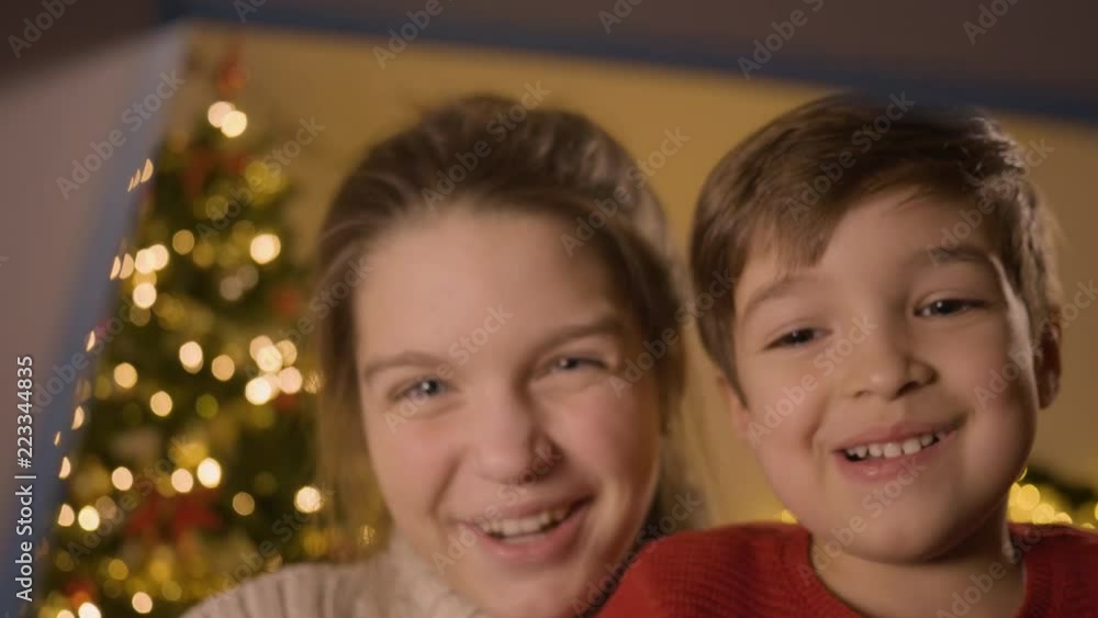 Shot of brother and sister opening a Christmas gift, filmed from the inside of the gift Shot of brother and sister opening a Christmas gift, filmed from the inside of the gift