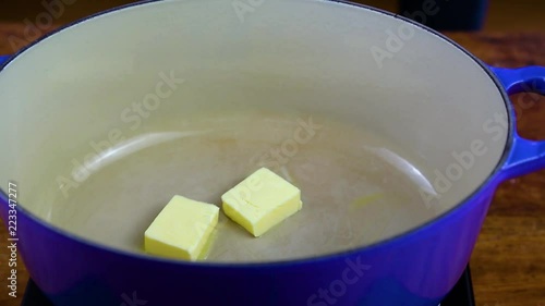 Butter slowly melting in a Le Creuset blue cast iron pot. photo