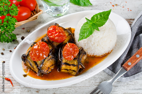 Meatballs wrapped in eggplant on a plate of rice