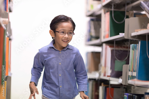Happy kids lifestlye in the Library. Young people explore lifestlye in the Library. Boy is love to read and learning.  Setup studio shooting.