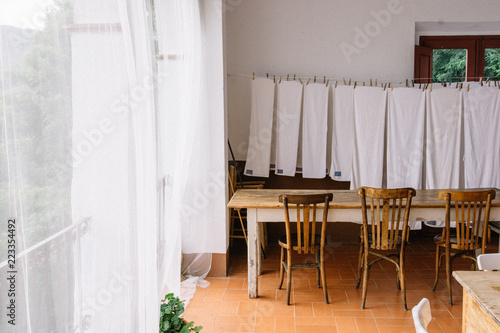 Salle à manger avec linge étendu rideaux blanc