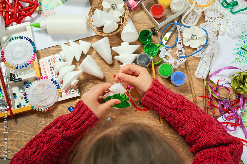 Fototapeta premium Dzieci robią dekoracje na święta nowego roku. Malowanie akwarelami. Widok z góry. Graficzne miejsce pracy z kreatywnymi akcesoriami.