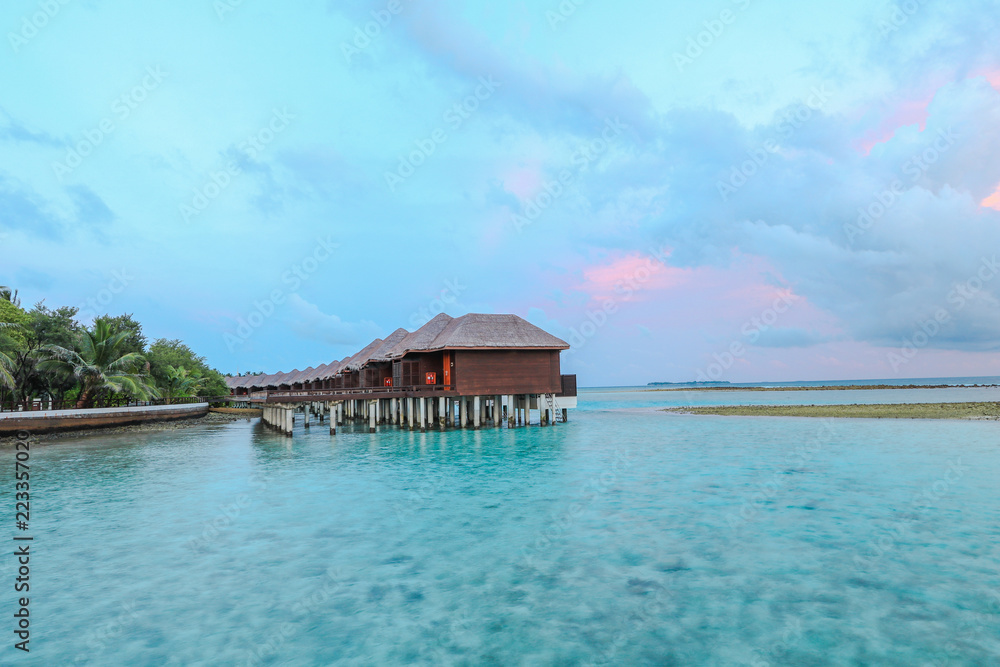 Amazing island in the Maldives ,water villa ,wooden bridge and  beautiful  turquoise waters with  blue sky  background for holiday vacation .