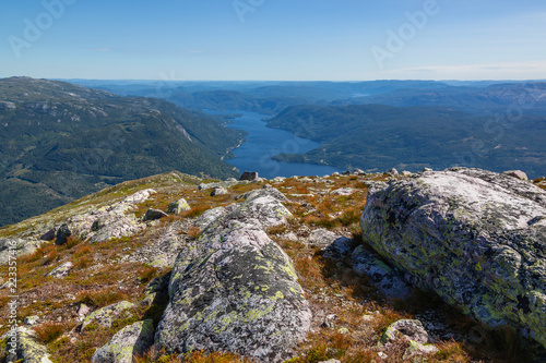 Magnificent view from the summits of the vastness Norwegian landscape with picturesque fjord with steep slopes covered with coniferous forest, Norway photo