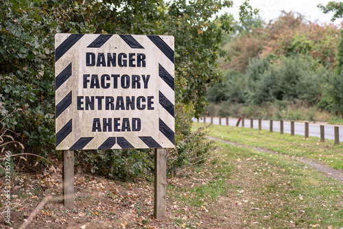 Danger Factory Entrance Ahead warning road sign on British road daylight view