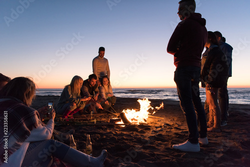 Friends having fun at beach on autumn day