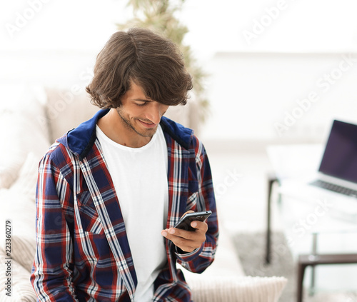 modern guy looking at screen smartphone at home
