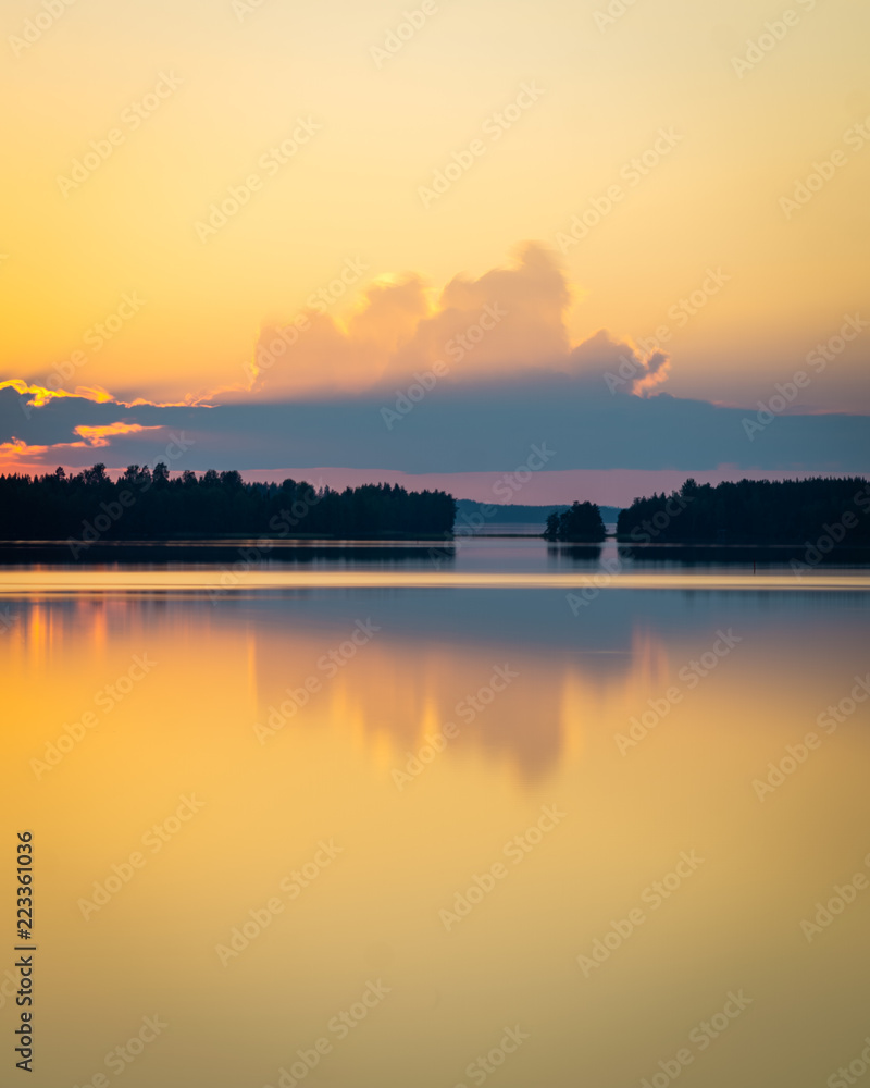 Obraz premium golden clouds and sunset in finnish lake