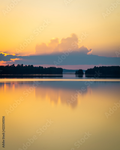 golden clouds and sunset in finnish lake