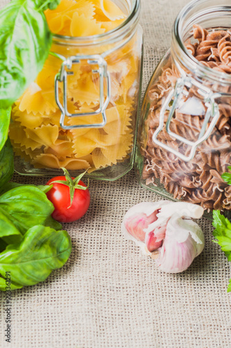 Ingredients for pasta - farfalle and fusilli, garlic, basil, cherry tomato