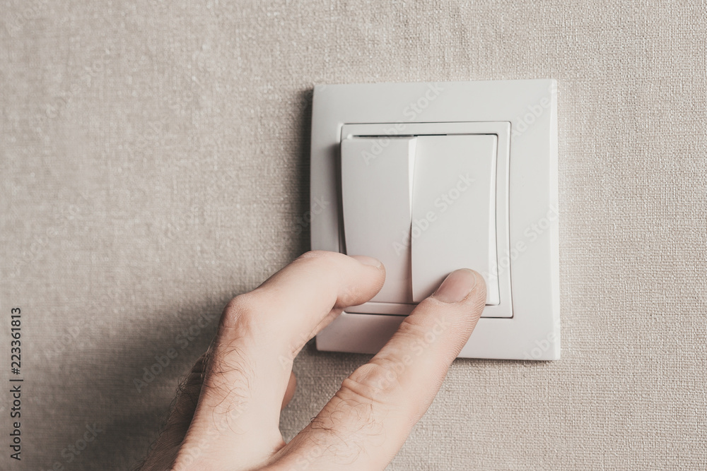 The man with his fingers turns on the light by pressing the white key The man with his fingers turns on the light by pressing the white key