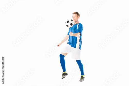 Fototapeta Naklejka Na Ścianę i Meble -  full length view of athletic young soccer player training with ball isolated on white