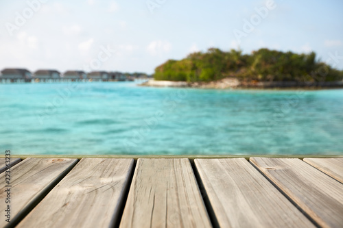 Empty white wood surface over blur blue ocean lagoon and sky and tropical for product placement and display.