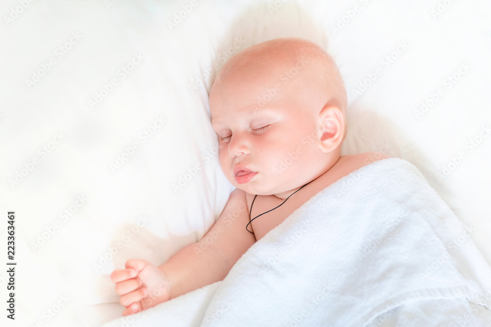 Cute little baby sleeping in bed indoors Cute little baby sleeping in bed indoors