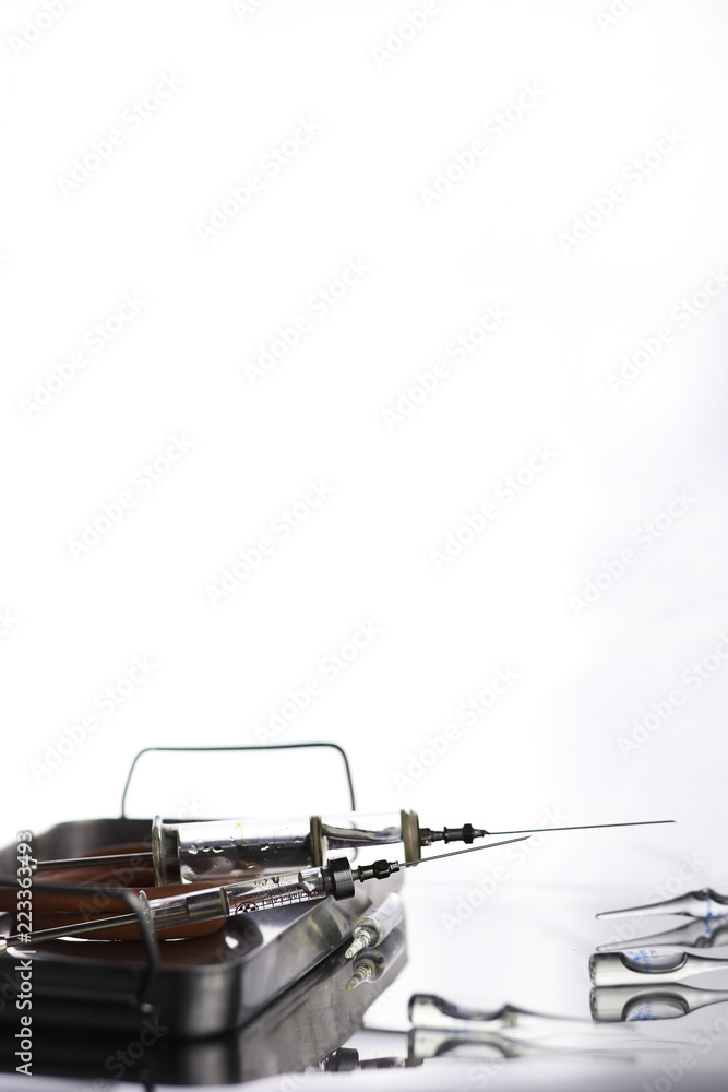 Naklejka premium Old metal medical syringe and accessories on the table