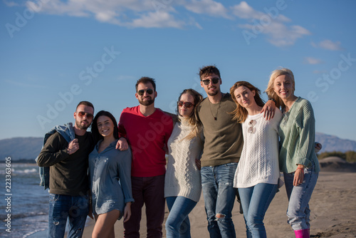 portrait of friends having fun on beach during autumn day