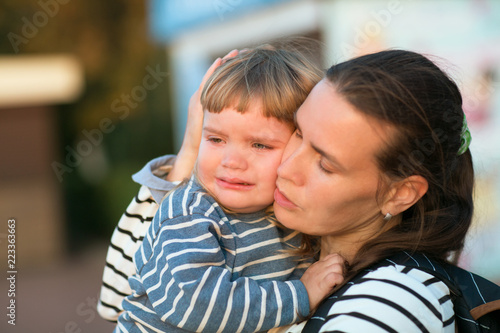 the child cries on hands at mother on walk