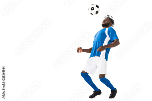Fototapeta Naklejka Na Ścianę i Meble -  athletic african american sportsman hitting ball with chest isolated on white