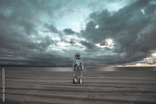 Spaceman standing alone at lake on nameless planet photo