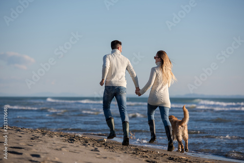 couple with dog having fun on beach on autmun day © .shock