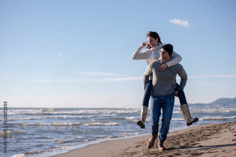 couple having fun at beach during autumn