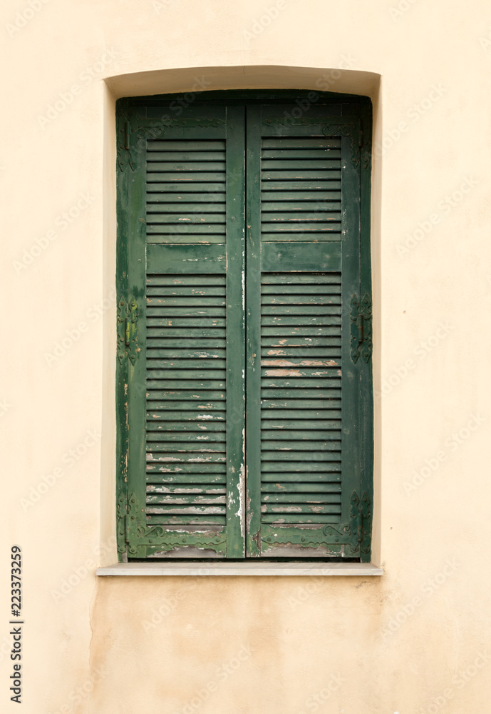 Old wooden window with green shutters.
