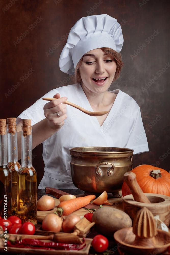 Young beautiful girl in a chef uniform with pan and wooden spoon tasting food. Young beautiful girl in a chef uniform with pan and wooden spoon tasting food.