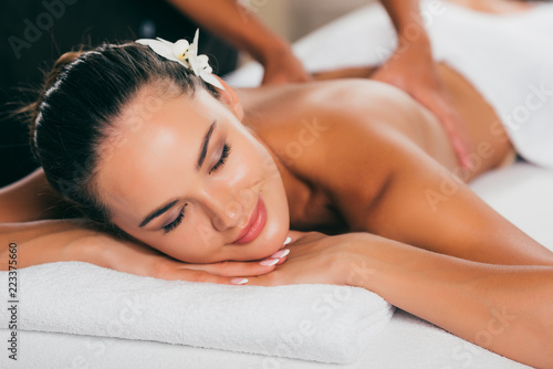relaxing woman having massage at spa salon