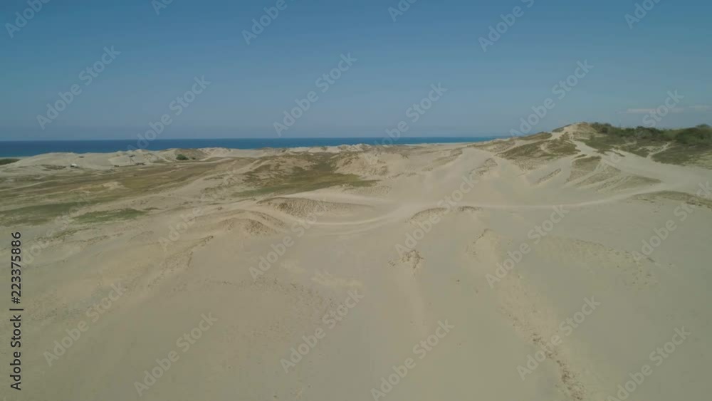Aerial view of beautiful lonely beach and Paoay sand dune. Philippines, Luzon. Sand dunes near to the sea with sky. Ilocos Norte.