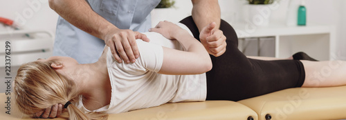Panorama on physiotherapist and woman with body pain during treatment