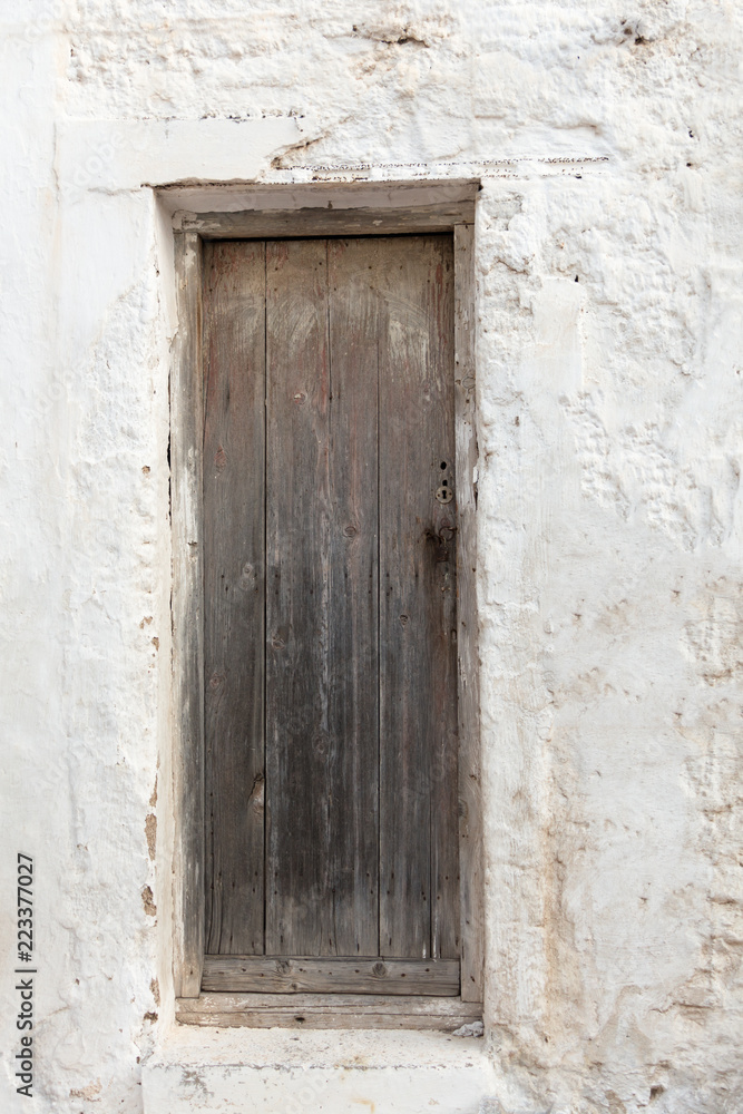 Old wooden door on grunge weathered wall.