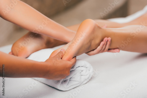 cropped view of woman relaxing and having feet massage in spa salon