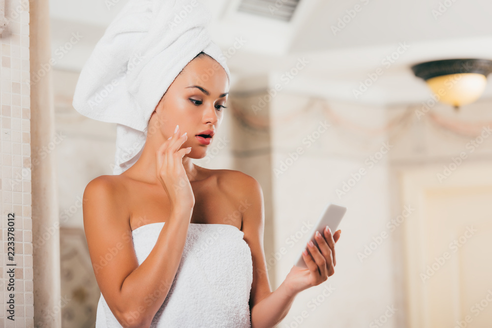 surprised woman using smartphone at spa salon surprised woman using smartphone at spa salon