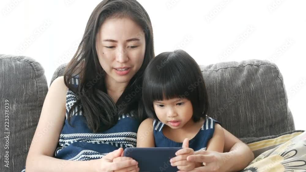 Mother and daughter are using smartphone with smile. 
