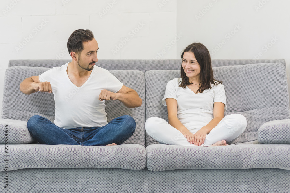 Loving couple on a new sofa are looking at each other. modern apartment. concept of comfort in a new apartment Loving couple on a new sofa are looking at each other. modern apartment. concept of comfort in a new apartment