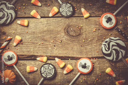 Halloween background - candies and lollipops, straws, wood background, top view