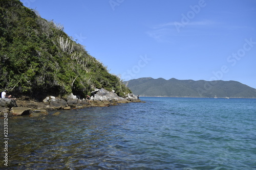 Praia com água azul turquesa e horizonte com colina verde, Arraial do Cabo	