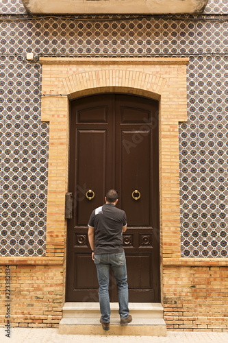 Hombre joven entrando en casa antigua.