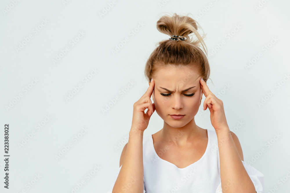 Young pretty woman looks tired, having a headache, dizzy, touching her temples while closing eyes. Isolated on white background. Young pretty woman looks tired, having a headache, dizzy, touching her temples while closing eyes. Isolated on white background.